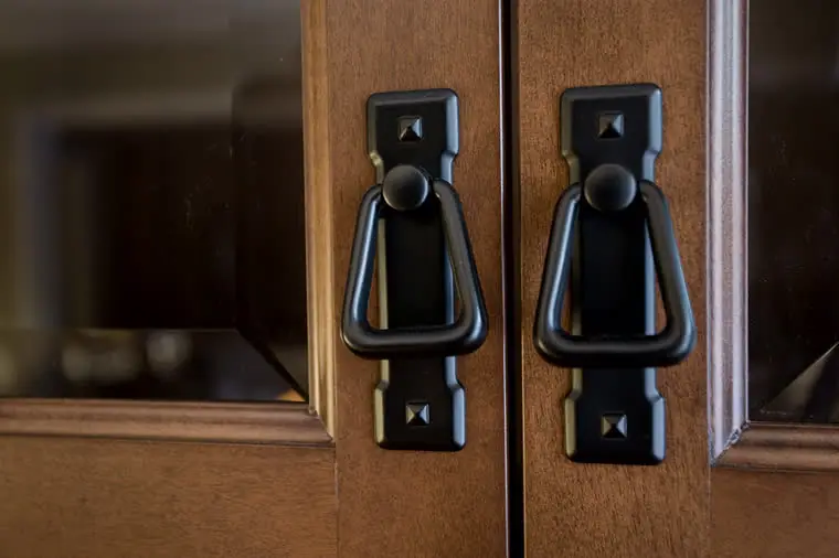 Black iron pulls on a cherry cabinet door